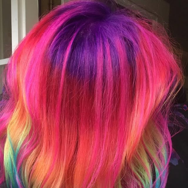 Vivid rainbow hair color blending magenta, purple, coral and mint.
